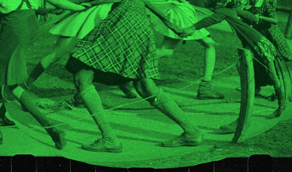 Image created by the artist Shenece Oretha. 
Girls in skirts holding hands and skipping in a circle. 
Neon green colour filter applied. 
